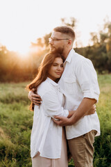 young couple in love a guy with a beard and a girl with dark hair in light clothes