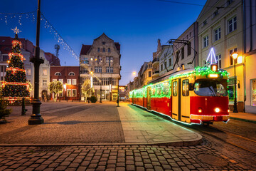Fototapeta na wymiar Christmas tram and decorations at the market square in Grudziądz at dusk. Poland