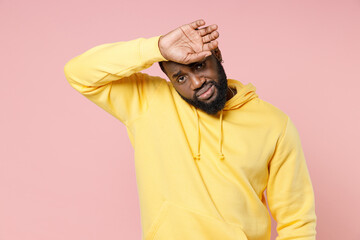 Exhausted tired young african american man 20s wearing casual basic yellow streetwear hoodie...