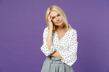 Tired pensive elderly gray-haired blonde woman lady 40s 50s years old wearing white dotted blouse...