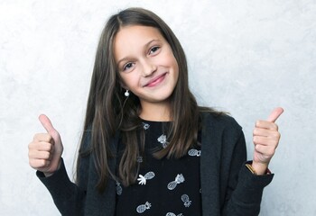 Smiling pretty girl showing thumbs up