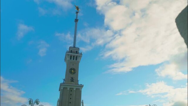 Spire of building of Rechnoi station in Moscow. Time laps and moving white clouds in the sky