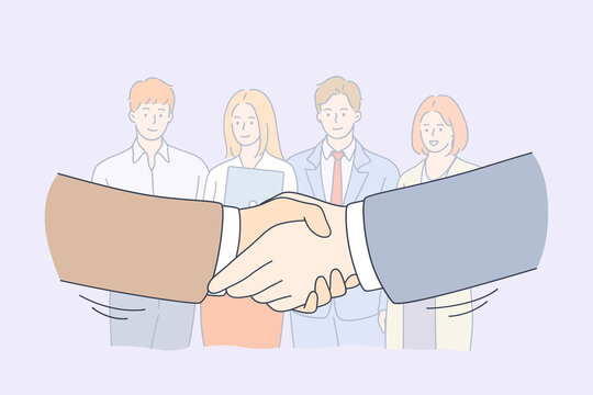 Handshake, Partnership, Business Cooperation Concept. Group Of Smiling Young Business Workers Colleagues Standing And Looking At Shaking Hands Of Head Managers Meaning Collaboration In Office 