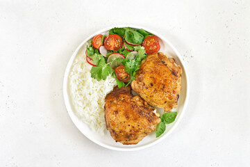Fried chicken thighs with vegetables and rice in plate