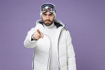 Displeased skier man in white windbreaker jacket ski goggles mask point index finger on camera...