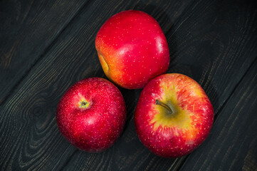 Three red apples on black boards. The idea of fasting diet after the holidays