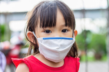 Portrait image of 2-3 yeas old baby. Happy Asian child girl smiling and wearing fabric mask,​ She...