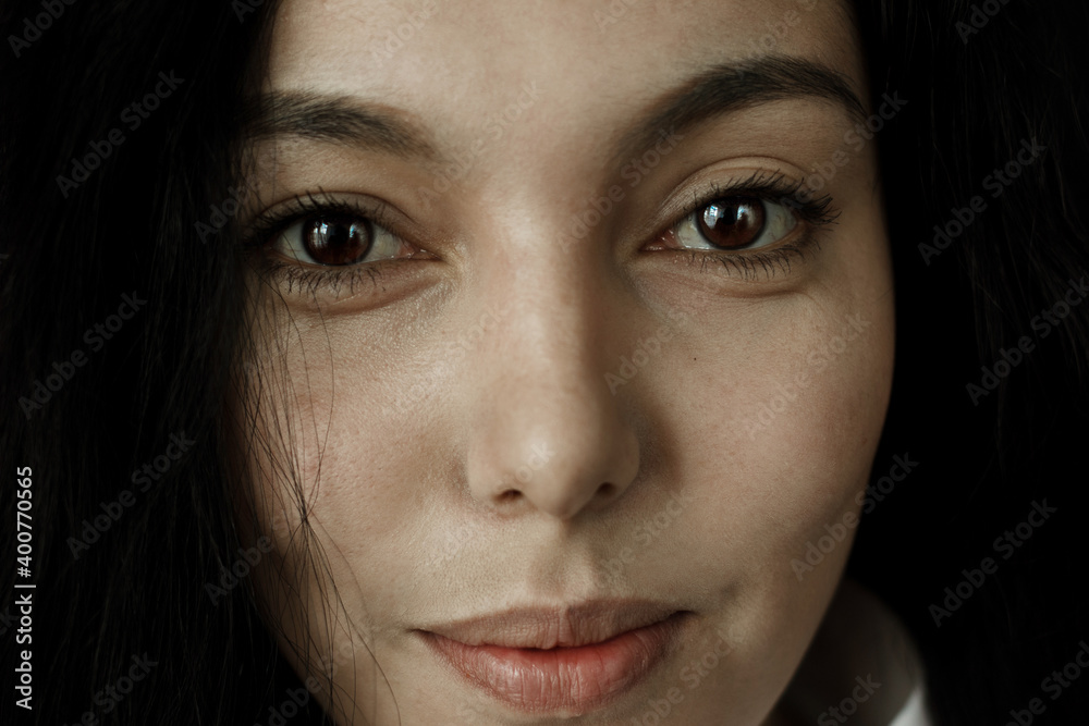 Wall mural Portrait of beautiful brunette young woman looking at camera.