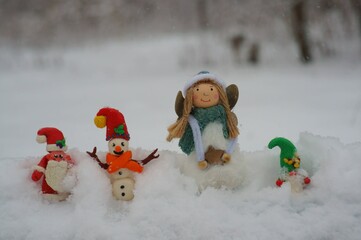 Figurine of santa claus, snowman and gnome on a background of snow. Nearby there is a Christmas...