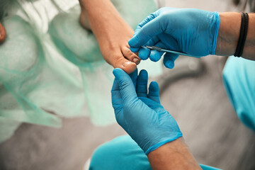 Competent podiatrist using professional instruments at work