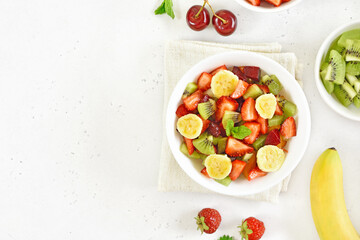 Healthy breakfast with fruit salad from strawberry, kiwi and banana in bowl