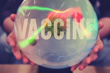 Women hands are guessing about the future of coronavirus vaccination on the ball of fate. Witch...
