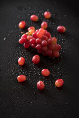 Top view closeup of red grapes isolated on a black background with water drops