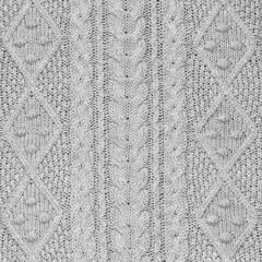 Silver grey knit fabric background or texture with vertical aran pattern of cables and rombs, square