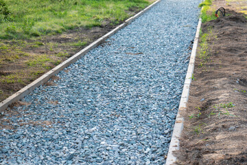 Repairing paths in the Park, installing curbs and sprinkling gravel before laying paving slabs