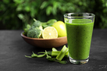 Delicious fresh green juice on black table. Space for text