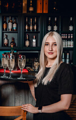 Girl waiter with sparkling wine glasses in a bar or restaurant