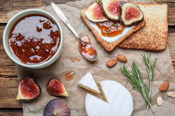 Flat lay composition with delicious fig jam on wooden table