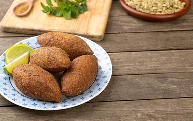 Traditional arabic fried kibbeh over wooden table with copy space. Typical brazilian snack