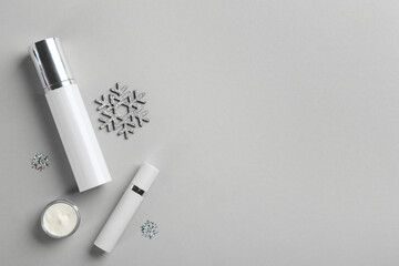 Flat lay composition with different cosmetic products on light grey background, space for text. Winter care