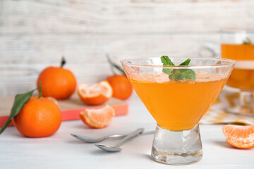 Delicious tangerine jelly in glass on white table