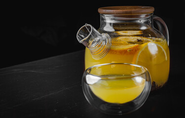 tea pot and Cup of Hot fruit tea with lemon, mint, orange on black background