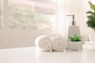 Soap dispenser and spa towel ,Roll up of white towels on white table with copy space,towels studio...