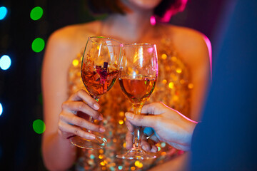 Close-up image of young couple talking and drinking wine at night party