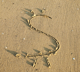 Fototapeta na wymiar Dollar sign is drawn in the sand