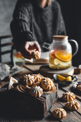 A woman reaches for a cake and drinks grapefruit tea. Healthy drink.