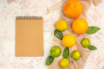 Above view of fresh citrus fruits on towel and notebook on white background
