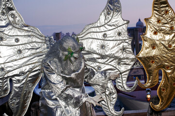 Carnival of Venice. A man dressed in carnival costume and posing along the waterfront in the evening. Veneto, Italy.