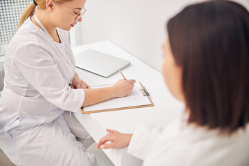 Patient sitting at a desk in front of a doctor