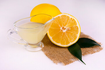 
Lemon juice and fresh lemons on a white background.
Close-up.