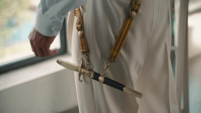 Poniard in case hang on strip on man. Naval dagger on seaman. Old retro knife. Soviet dirk. Marine