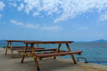 Picnic table standing near to the sea, no people, selective focus