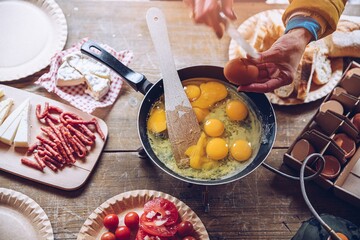 Delicious tourist breakfast on the camping. Frying scrambled eggs outdoors.