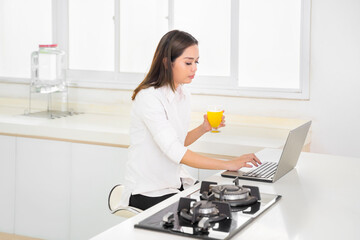 Woman drinks orange juice while work from home