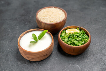 bottom view bowls with rice natural yogurt parsley on dark background with copy space