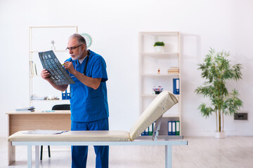Old male doctor radiologist working in the hospital