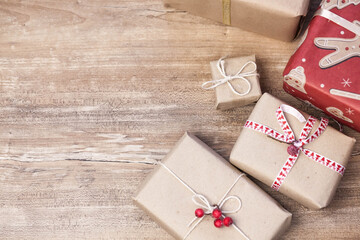 Christmas gift boxes and glowing garland on wooden background. New Year presents.