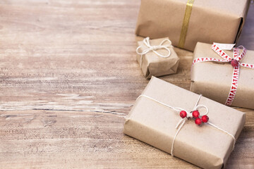 Christmas gift boxes and glowing garland on wooden background. New Year presents.