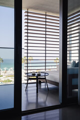 Fototapeta premium Open terrace with a cofee table on it and two white tea cups on a balcony with a beautiful view on a beach. 