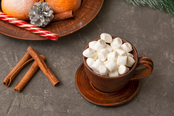 Clay cup with drink and marshmallows in New Year's composition on concrete background. Close-up, selective focus