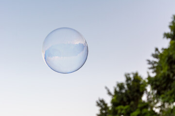 A soap bubble flying in the blue and clean sky