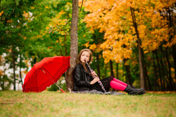 Naklejka na ściany i meble Young attractive smiling girl under umbrella in autumn forest