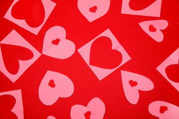 Background of Lot of identical red pink cut out paper hearts lying staggered on red background. Symbol of love, tenderness and passion.
