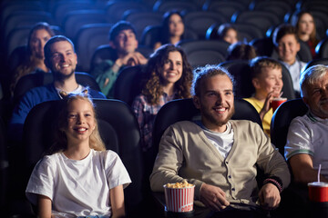 Fototapeta premium Young man with younger sister in cinema.