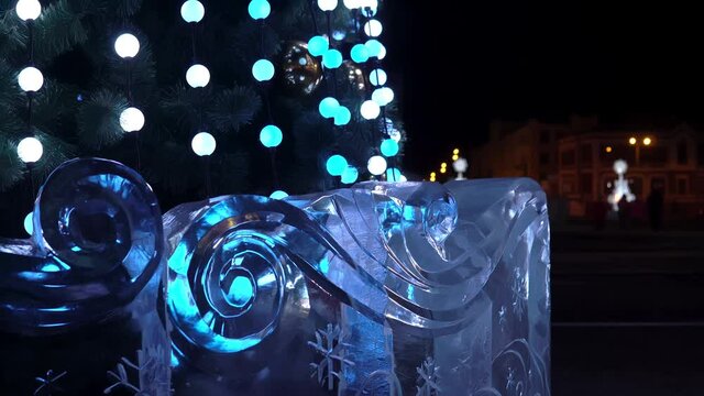 Ice sculpture decorates the Christmas tree. Christmas tree flashes lights and illuminates ice sculpture
