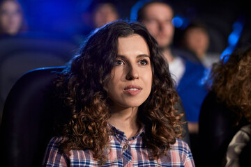 Fototapeta premium Young girl enjoying free time in movie theater.